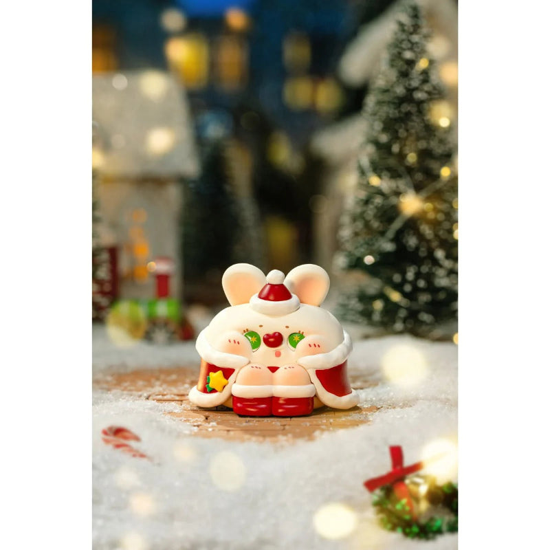 Decorative mouse figurine with Santa hat in a festive setting with Christmas tree and lights.