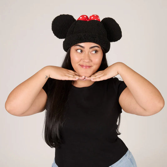 Person wearing a black knit hat with red accents and black ears, posing against a plain background.
