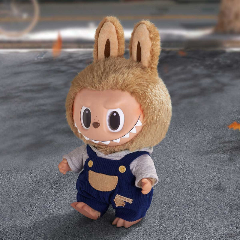 Toy figure of a character with animal ears and overalls on a gray surface