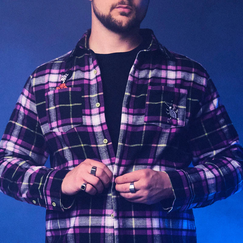 Man wearing a purple plaid shirt against a blue background