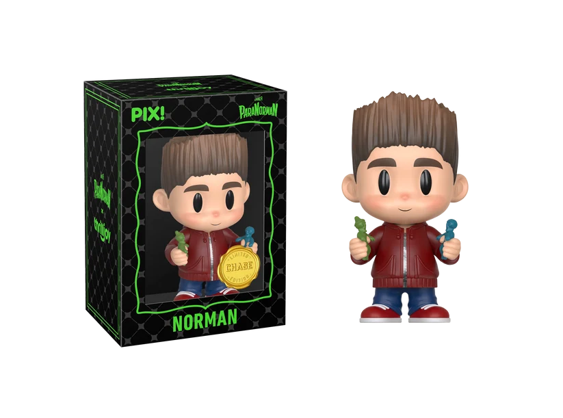 PIX! Norman chase figure in a red jacket holding small green and blue figurines, shown beside its black window box with the figure inside.