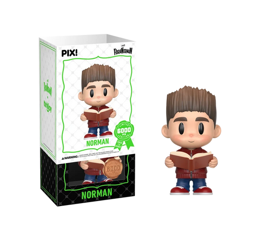 PIX! Norman vinyl figure in a red jacket and jeans holding an open book, shown beside its box with the white outer sleeve partly lifted.
