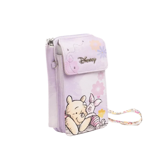 A light purple Disney crossbody phone pouch featuring Winnie the Pooh and Piglet illustrations, with a matching floral wrist strap, shown on a white background.