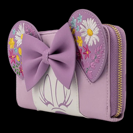 A lavender purple wallet designed like Minnie Mouse's ears, featuring a large lavender bow on the front, embroidered floral details on the ears, and a white central stripe with purple Minnie Mouse line art. It has a gold zipper on the right side.