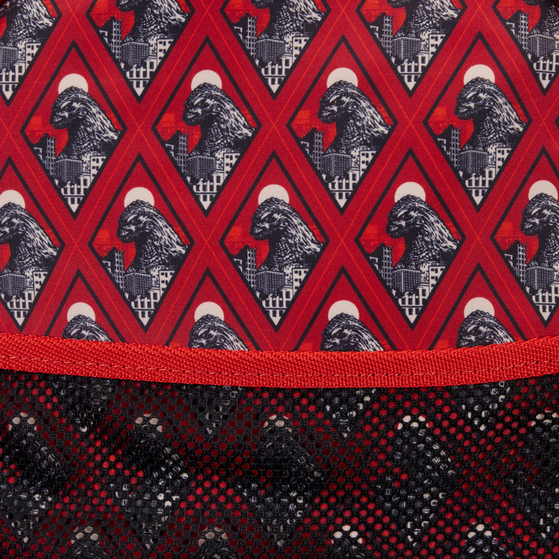 Close-up of a fabric with a red and black geometric pattern featuring a mountain and moon design.