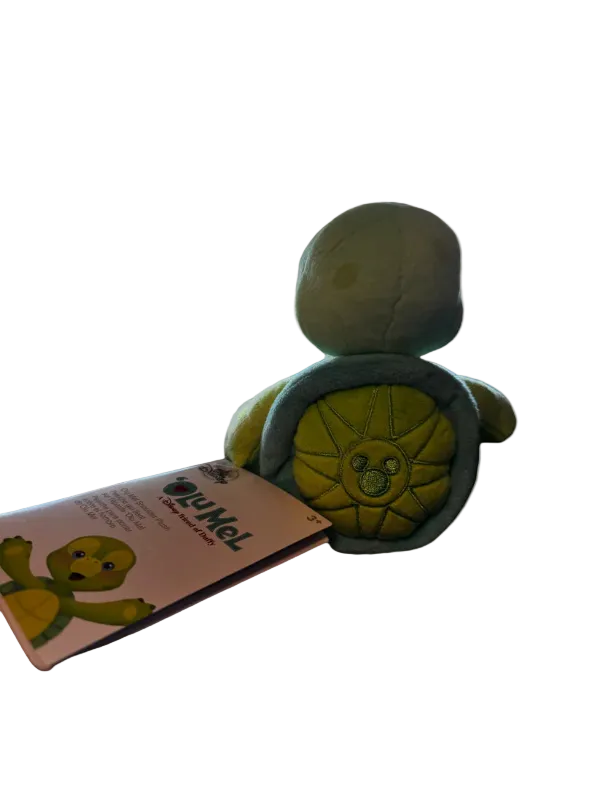 Toy turtle with wheels and a pink card featuring a turtle illustration on a white background
