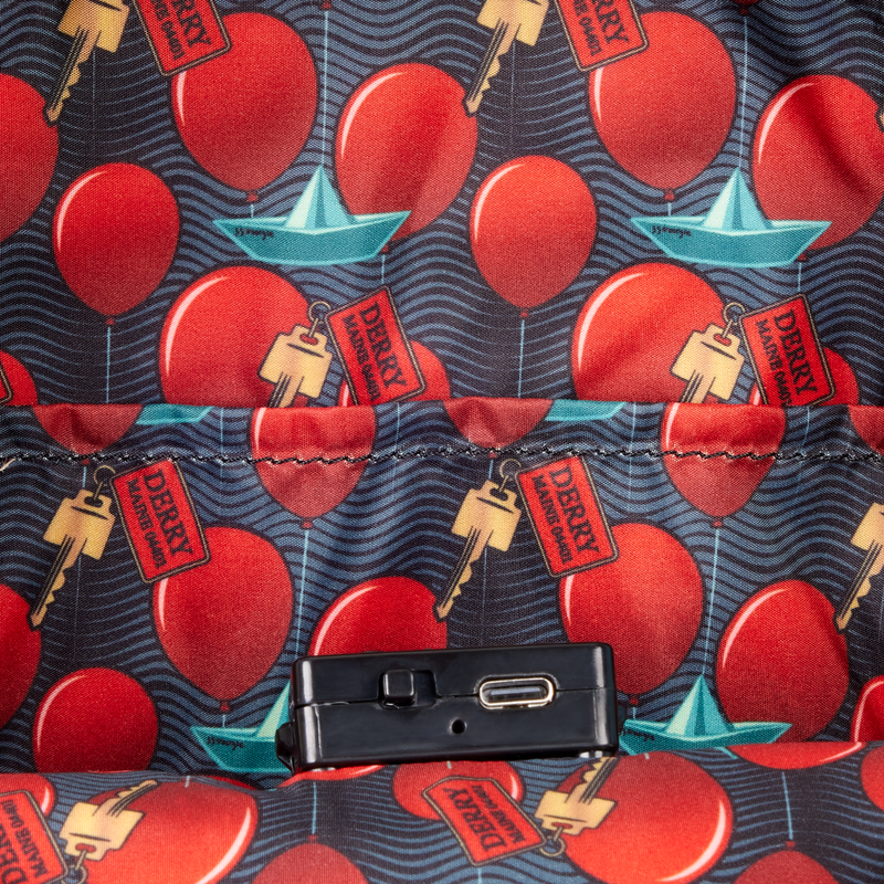 Patterned fabric with red balloons, blue boats, and 'Derry' tags on a dark background.