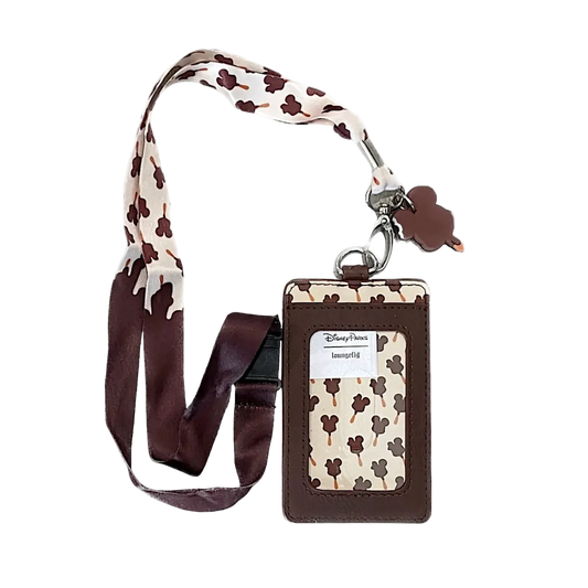 A Disney-themed employee ID badge holder with a matching lanyard. The holder features a brown faux-leather border and a cream fabric insert patterned with brown Mickey Mouse silhouettes.