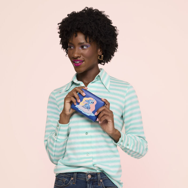 Woman holding a product against a light pink background