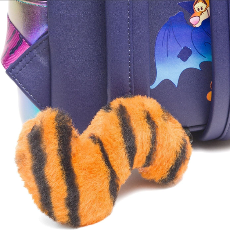 Plush tiger paw toy with a blue bag featuring cartoon characters in the background