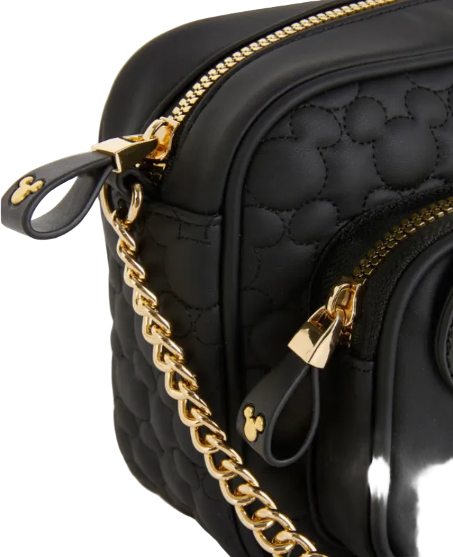 Black quilted handbag with gold chain and accents on a light gray background