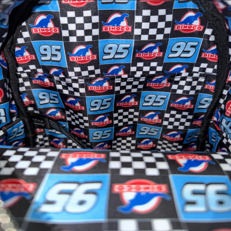 Close-up of a patterned fabric with logos and numbers, including 'Dinoco' and '95'.