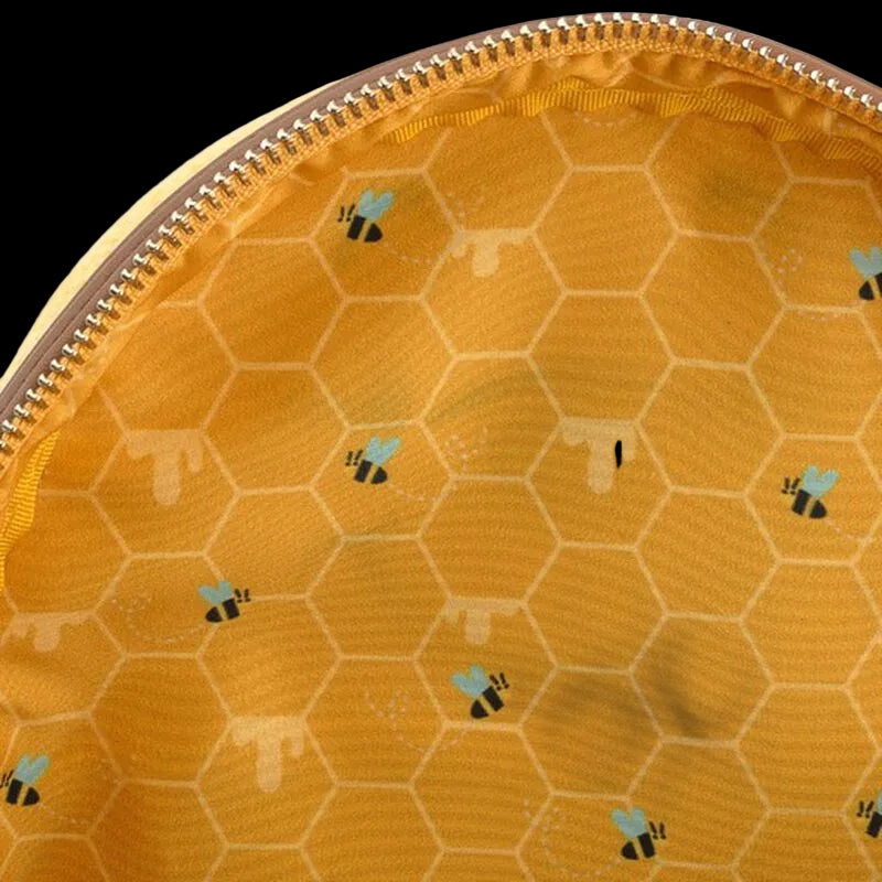 Close-up of a yellow fabric with honeycomb pattern and bee designs, featuring a zipper.