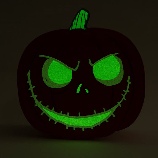 Glowing black pumpkin with green face on a dark background