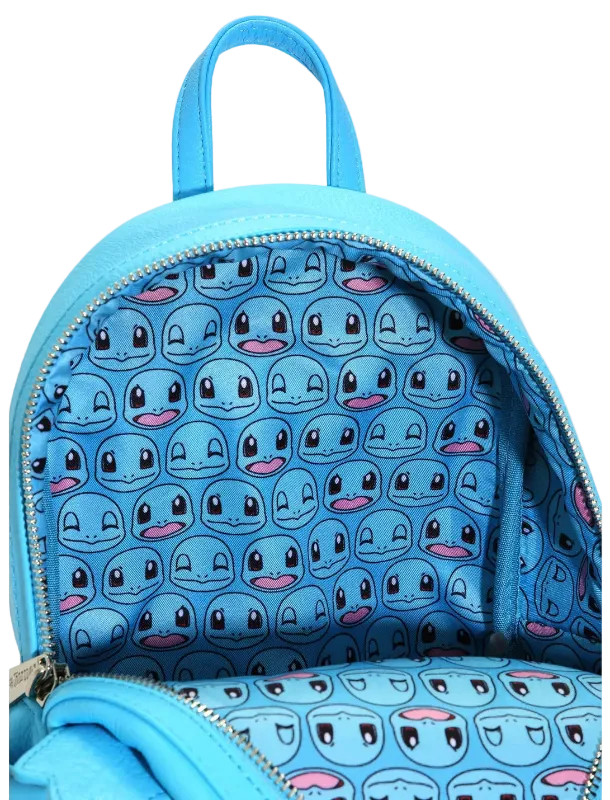 A light blue backpack shown open, featuring a repeating pattern of cartoon character faces on the interior lining and matching exterior material.