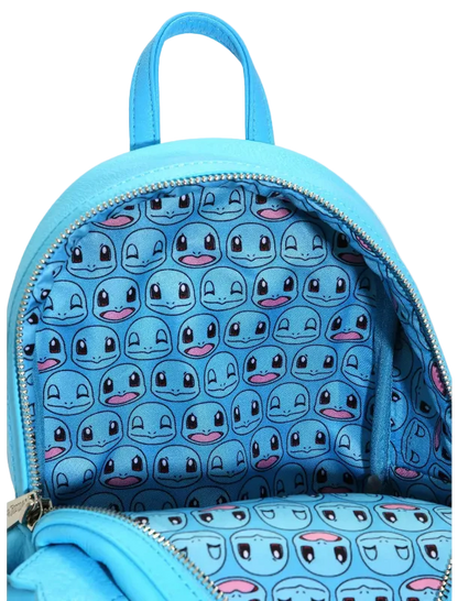 A light blue backpack shown open, featuring a repeating pattern of cartoon character faces on the interior lining and matching exterior material.