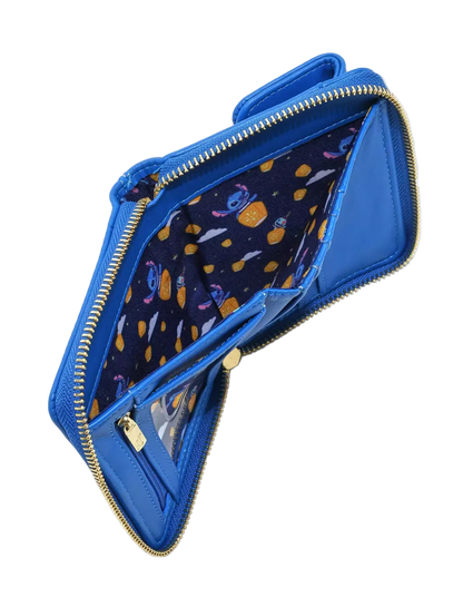 A blue zip-around wallet shown open to display its interior, featuring a dark navy patterned lining with cartoon characters and gold-tone zippers.