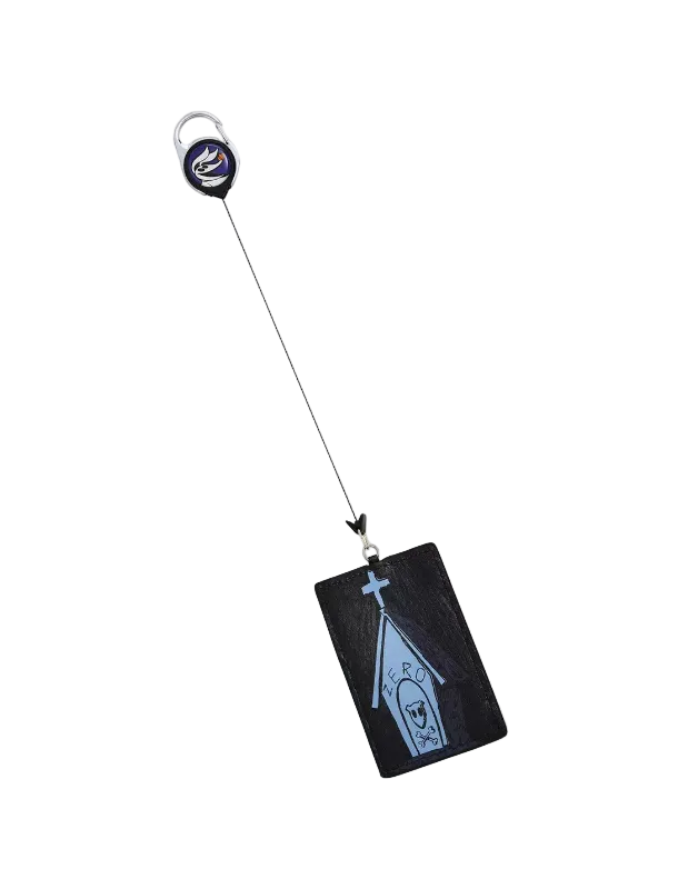 A black rectangular card holder or ID tag with a light blue coffin-shaped graphic and a small cross, attached to a black retractable badge reel with a silver key ring, shown on a plain light gray background.