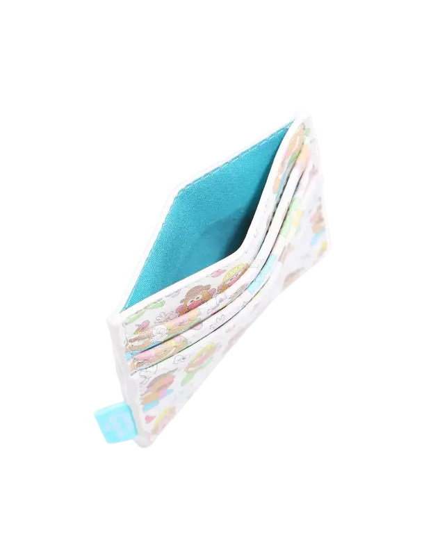 A slim card holder wallet with a white background, pastel multicolor cartoon pattern on the exterior, and a bright turquoise blue interior lining, shown open on a light gray background.