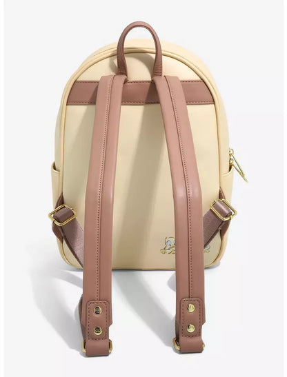 A cream-colored mini backpack with dusty rose brown straps and trim, featuring a small embroidered character on the lower right and gold-tone hardware, shown from the back against a light gray background.