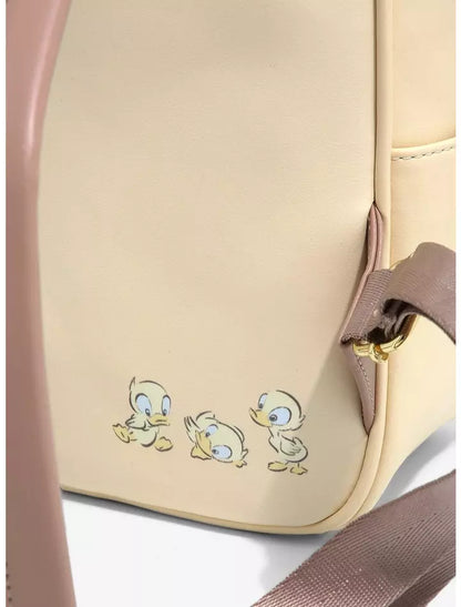Close-up of a beige backpack featuring three cartoon ducklings printed near the bottom left, with a taupe shoulder strap and gold-tone hardware visible on the right side.