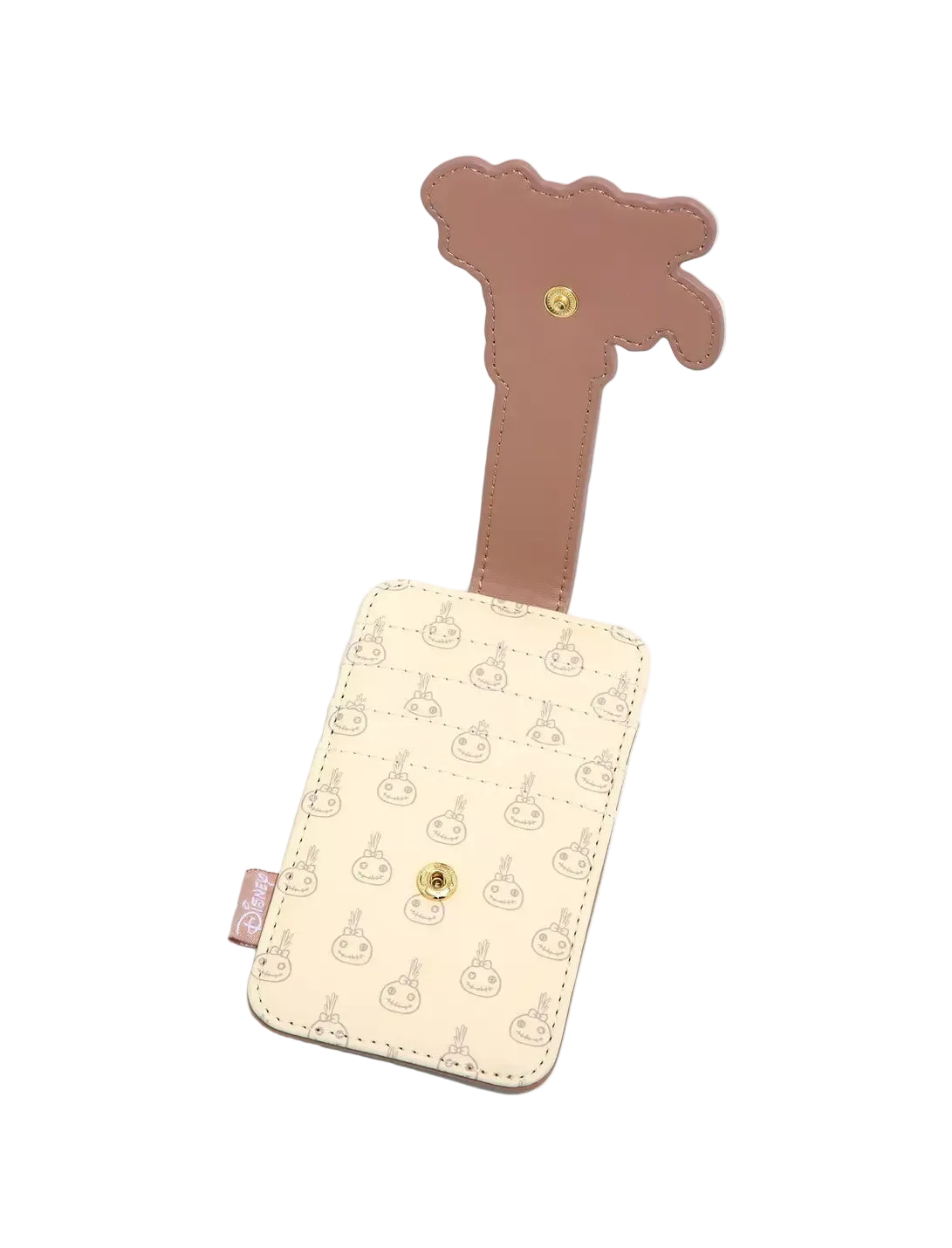 A cream-colored luggage tag featuring a repeating pattern of cartoon characters, with a brown strap shaped like a giraffe and a gold snap button closure.