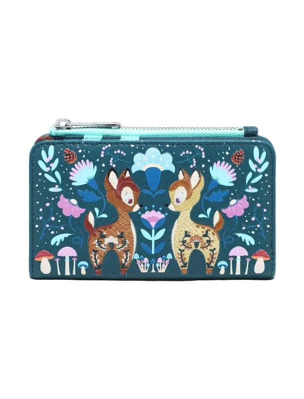 A rectangular zip-around wallet featuring a whimsical forest illustration with two deer, flowers, mushrooms, and a turquoise zipper, shown on a plain light gray background.
