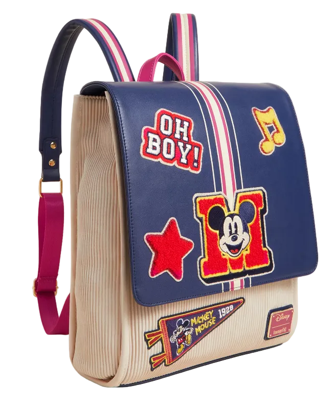 Backpack with colorful patches and a prominent 'M' design on a beige background