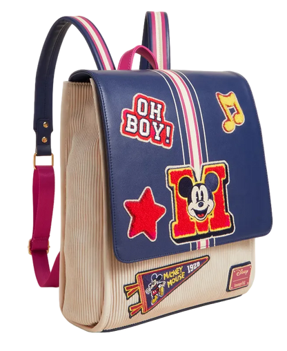 Backpack with colorful patches and a prominent 'M' design on a beige background