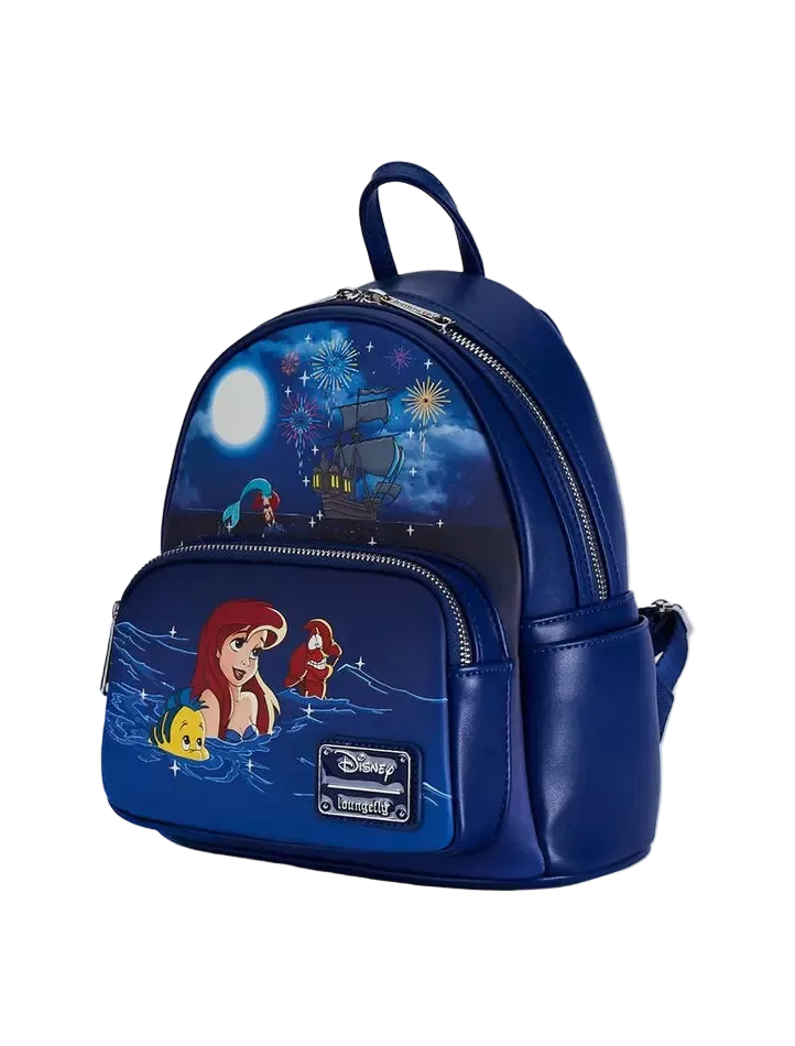 A blue faux-leather Disney/Loungefly mini backpack featuring characters from The Little Mermaid, including Ariel, Sebastian, and Flounder, with a navy night-sky print on the upper half and a front pocket with character graphics.