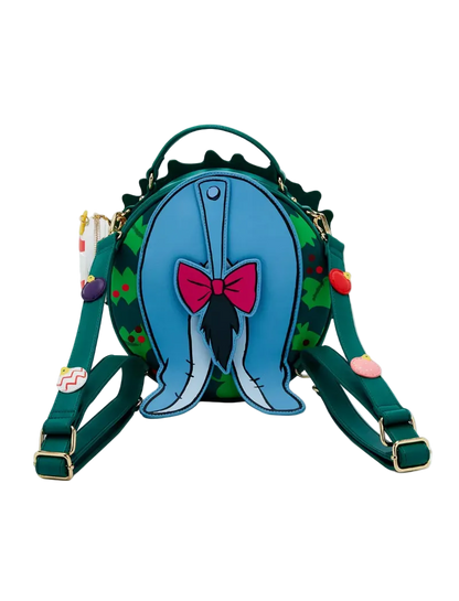 A green and blue Whimsical Wicked Bag backpack featuring a 3D blue whale tail design with a pink bow on the front, set against a plain white background.