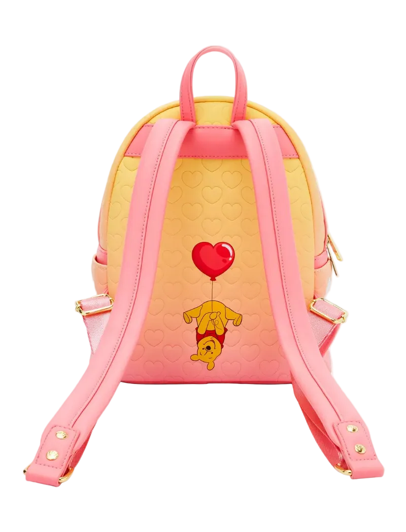 A pink and yellow mini backpack featuring a cute graphic of Winnie the Pooh holding a red heart balloon, shown from the back against a light gray background.