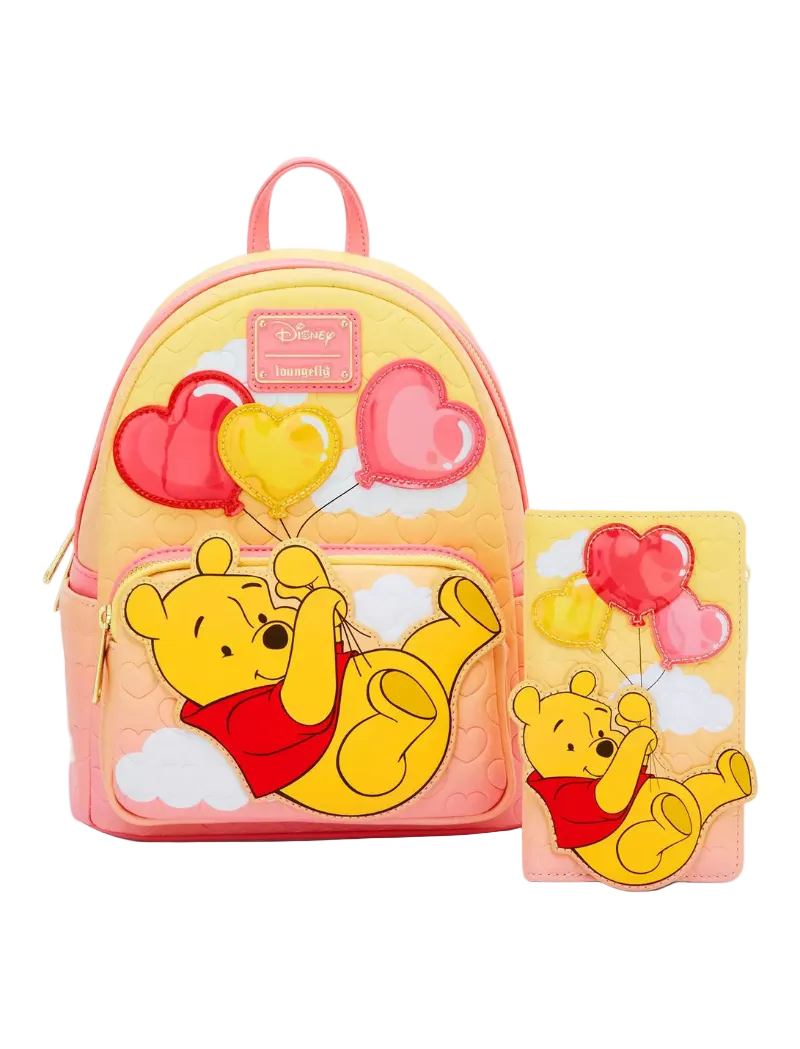 A pink and yellow Disney Winnie the Pooh backpack set shown with a matching zip-around wallet. The set features a 3D applique of Winnie the Pooh lying on clouds and holding pink and yellow heart balloons, with a pink quilted background and a pink top handle.
