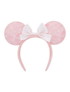 A pink and white Minnie Mouse-themed headband with round ears featuring a subtle bow pattern and a central white bow with pink polka dots, shown against a plain white background.