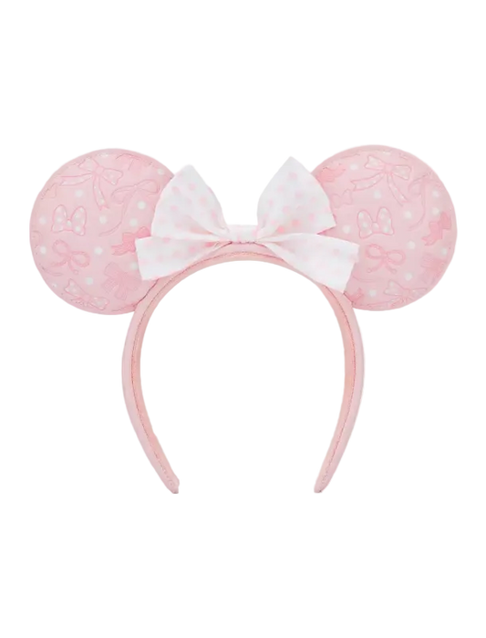 A pink and white Minnie Mouse-themed headband with round ears featuring a subtle bow pattern and a central white bow with pink polka dots, shown against a plain white background.