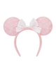 A pink and white Minnie Mouse-themed headband with round ears featuring a subtle bow pattern and a central white bow with pink polka dots, shown against a plain white background.