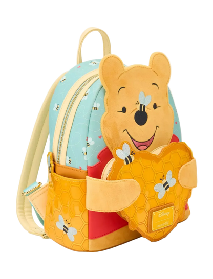 Backpack with a cartoon bear design holding a honeycomb, on a light gray background