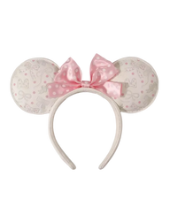 A Minnie Mouse-inspired headband with round ears covered in a light beige and pink Disney-themed pattern, featuring a large pink polka-dot bow on a white background.