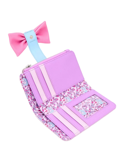 A pastel purple and pink wallet with a light blue bow, featuring floral patterned accents and card slots, shown on a light gray background.