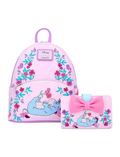 A pink Disney-themed mini backpack and matching wallet set featuring a blue sleeping character, floral patterns, and a large pink bow on the wallet, shown on a light gray background.