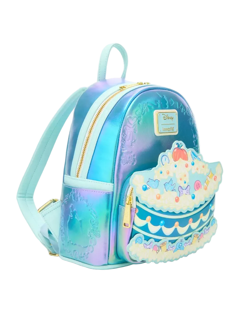 A small iridescent backpack with a pastel blue and purple gradient finish, featuring a tiered cake applique on the front pocket and a visible Disney logo patch.