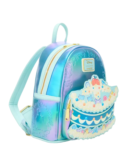 A small iridescent backpack with a pastel blue and purple gradient finish, featuring a tiered cake applique on the front pocket and a visible Disney logo patch.