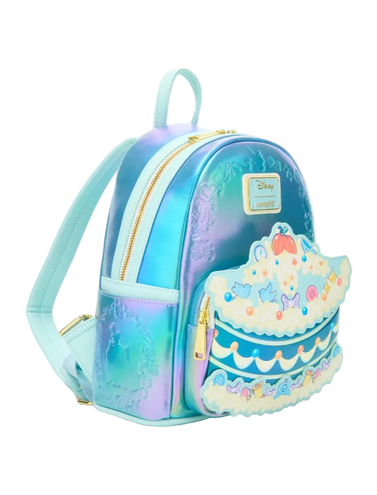 A small iridescent backpack with a pastel blue and purple gradient finish, featuring a tiered cake applique on the front pocket and a visible Disney logo patch.