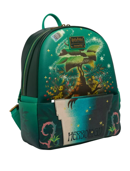 A Loungefly x Harry Potter Herbology backpack in a dark teal green color, featuring a detailed illustration of a Herbilong tree with a frog, magical sparkles, and the word 'HERBATOLOGY' on the front pocket.
