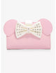 A pink faux-leather clutch bag featuring Minnie Mouse-inspired round ears and a large white bow embellished with rhinestones, shown against a plain white background.