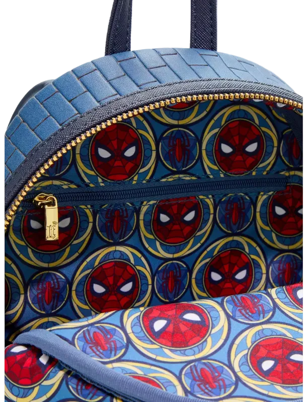 Close-up of a blue backpack with a woven texture on the upper section and a Spider-Man-themed print on the lower section, featuring red and blue Spider-Man masks inside gold circular frames.