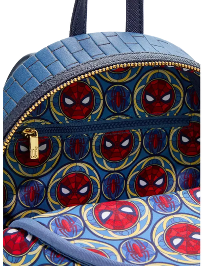 Close-up of a blue backpack with a woven texture on the upper section and a Spider-Man-themed print on the lower section, featuring red and blue Spider-Man masks inside gold circular frames.