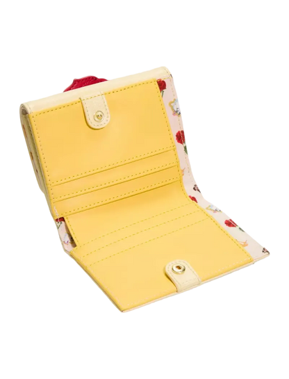 A yellow bifold wallet shown open, featuring a smooth yellow exterior, cream-colored snap-button tabs, and a floral patterned interior lining with red and green accents.