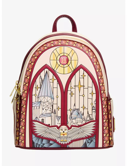 A small backpack styled like a stained-glass window, featuring a cream background with red borders, gold star details, and an illustration of Hogwarts and an owl at the bottom.
