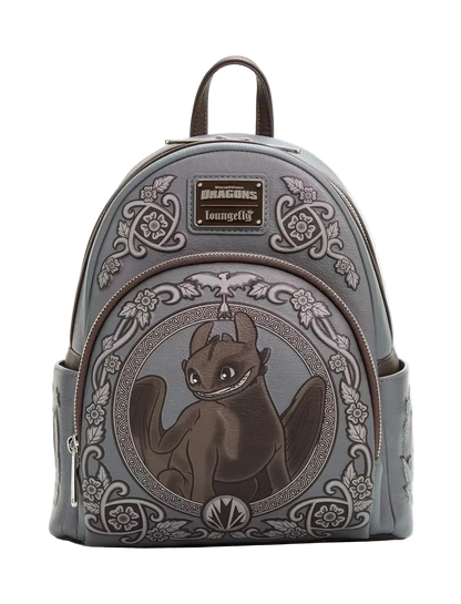 A gray faux-leather mini backpack featuring an embossed and printed design of Toothless from 'The Dream Team' in the center, with ornate floral scrollwork and a 'loungertify' brand patch on the front.
